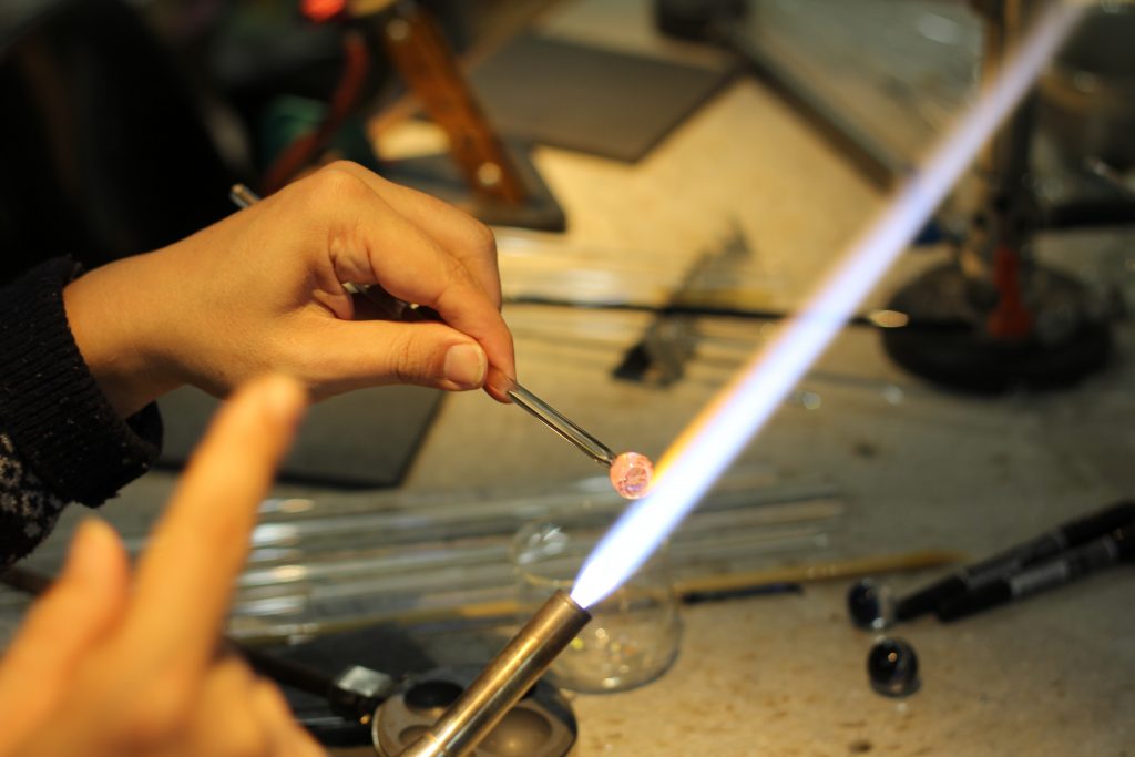 溶けたガラスを丸めて整えます